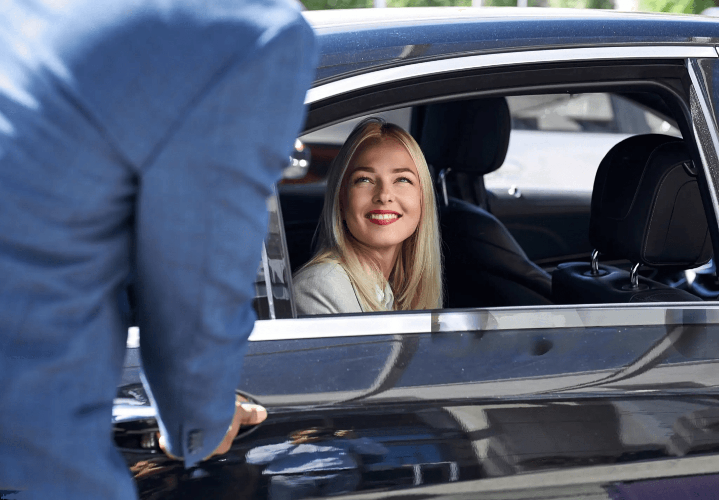 Corporate woman sitting and smiling in car