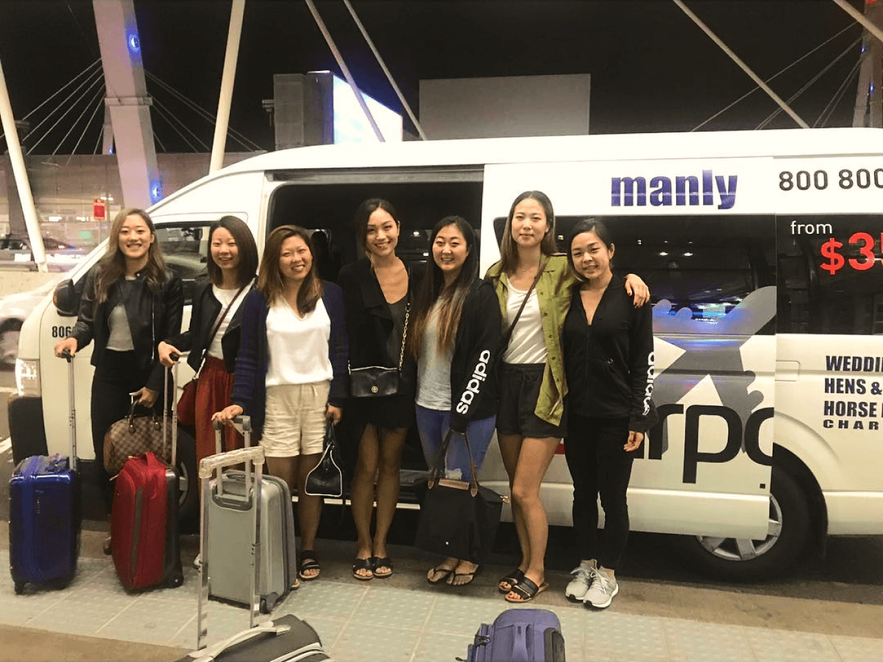 A group of smiling people standing in front of shuttle