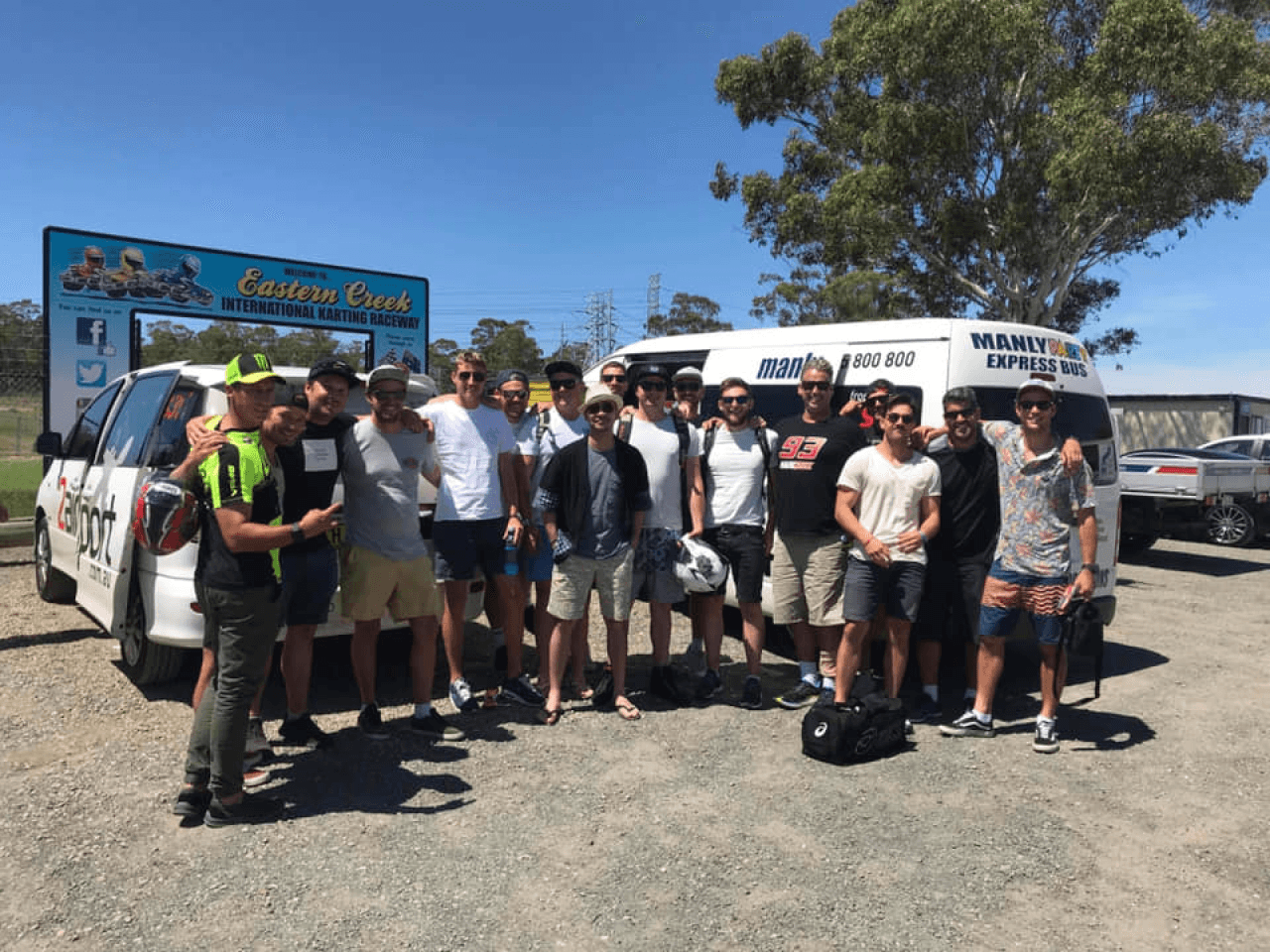 A large group of smiling people standing in front of multiple shuttles